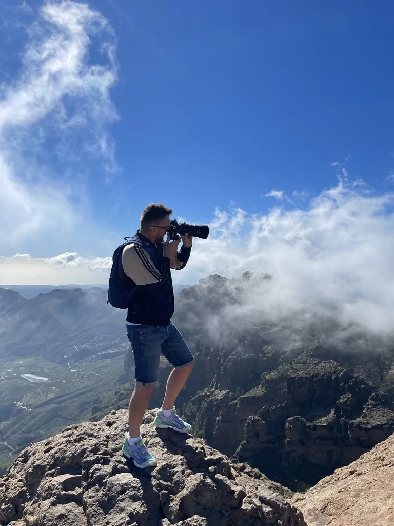 André photographing a sea of clouds from the edge of a cliff