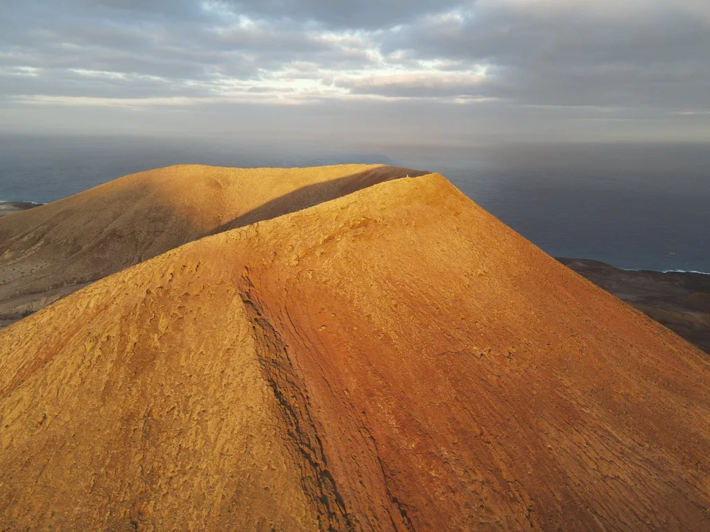 A volcanic ridge glowing orange in evening light